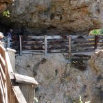 Wandeern zum Wallfahrtsort San Romedio am steilen Felshang. Der Weg diente einst ähnlich einer Levada zur Wasserversorgung.